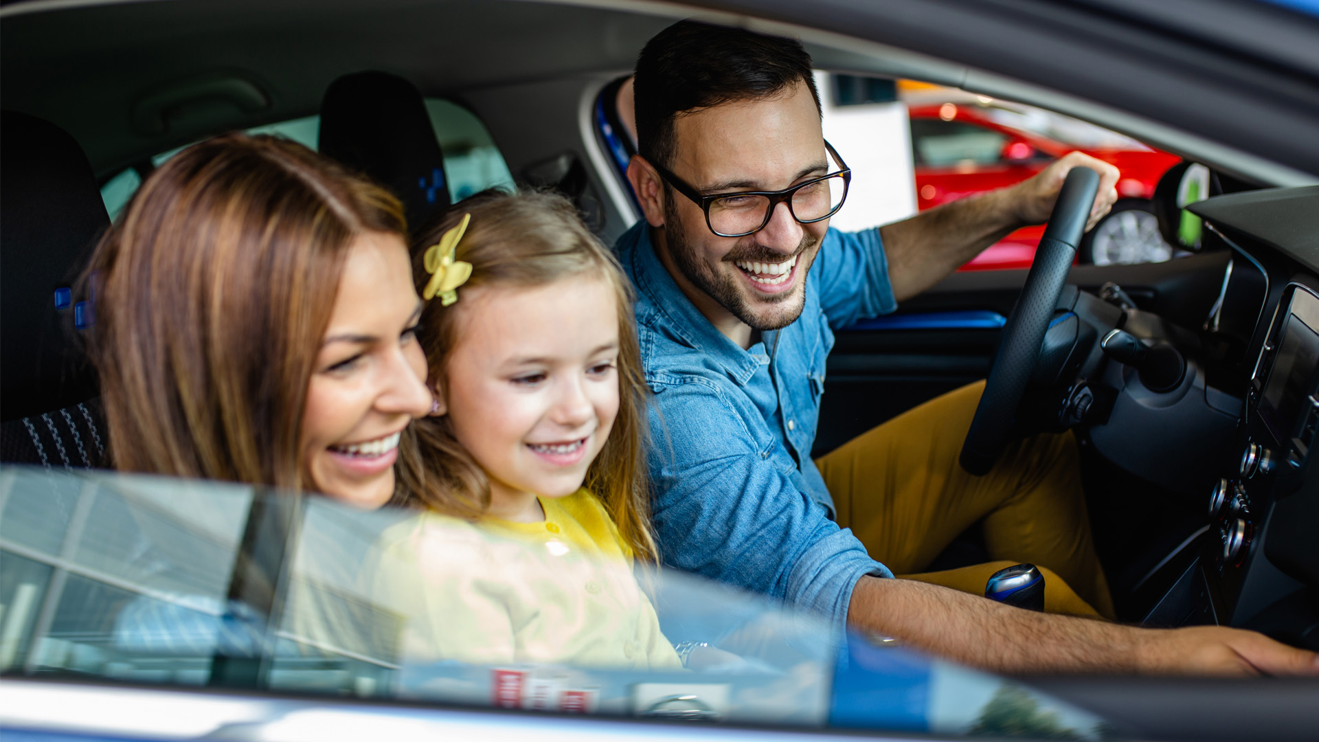 Parents and child in new car.